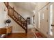 Bright foyer with hardwood floors, a staircase with wood banister, and a view into a carpeted living area at 757 Howe Dr, Carmel, IN 46032