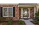Close-up of the home's entrance, highlighting the brick facade, a window with shutters, and a welcoming front door at 757 Howe Dr, Carmel, IN 46032