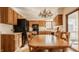 Eat-in kitchen with natural wood cabinets, black appliances, and an adjacent dining table at 757 Howe Dr, Carmel, IN 46032