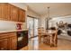 Kitchen with eat-in space showing updated appliances, wood cabinets, and access to the living room at 757 Howe Dr, Carmel, IN 46032