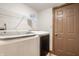 Bright laundry room featuring a front-load washer and dryer, shelving and a painted door at 757 Howe Dr, Carmel, IN 46032