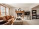 Inviting living room featuring a brick fireplace, plush seating, and natural light from large window at 757 Howe Dr, Carmel, IN 46032
