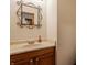 Powder room with oak cabinets, white countertops, decorative mirror, and modern faucet at 757 Howe Dr, Carmel, IN 46032