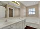 Bright bathroom with double sink vanity, soaking tub, and recessed lighting at 7637 Sand Run Ct, Indianapolis, IN 46259