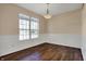 Well-lit dining room showcasing hardwood floors, white wainscoting, and a stylish light fixture at 7637 Sand Run Ct, Indianapolis, IN 46259
