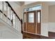 A home's entryway with a decorative front door featuring sidelights and a staircase with white risers at 7637 Sand Run Ct, Indianapolis, IN 46259