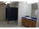 This public restroom features multiple stalls, sleek tile flooring, and a sink with wood cabinetry at 809 S Harrison St, Alexandria, IN 46001