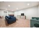 Spacious basement featuring plush carpeting, a large blue sofa, and a television for entertainment at 8452 Ironhill Ct, Indianapolis, IN 46259
