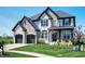 Beautiful two-story home with a well-manicured lawn and a charming front porch with black accents and stone details at 8452 Ironhill Ct, Indianapolis, IN 46259