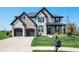 Beautiful two-story home with a well-manicured lawn and a charming front porch with black accents and stone details at 8452 Ironhill Ct, Indianapolis, IN 46259