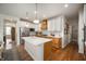 Well-equipped kitchen featuring an island, white cabinets, wood-look lower cabinets, and stainless steel appliances at 8452 Ironhill Ct, Indianapolis, IN 46259