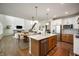 Bright, open kitchen featuring an island with a sink, stainless steel appliances, and adjacent dining and living spaces at 8452 Ironhill Ct, Indianapolis, IN 46259