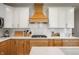 Close-up of kitchen featuring white counters, white upper cabinets, wood-look lower cabinets, and stainless steel appliances at 8452 Ironhill Ct, Indianapolis, IN 46259