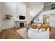 Bright living room featuring a cozy fireplace, staircase with black railings, and a comfortable white sofa with warm accents at 8452 Ironhill Ct, Indianapolis, IN 46259