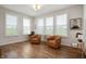 Bright sitting room featuring wood-look floors, large windows with plantation shutters, and comfortable seating at 8452 Ironhill Ct, Indianapolis, IN 46259