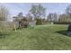 Large backyard features a wooden playset with a slide, a shed, a swing, and plenty of green grass at 8926 New Heritage Ct, Indianapolis, IN 46239