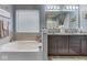 Well-lit bathroom features a large soaking tub and dual sinks, creating a spa-like retreat at 8926 New Heritage Ct, Indianapolis, IN 46239