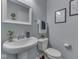 Charming powder room features a pedestal sink, decorative mirror, and elegant decor accents at 8926 New Heritage Ct, Indianapolis, IN 46239