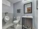 Bathroom features a toilet, urinal, vanity, and framed mirror, all decorated in gray tones at 8926 New Heritage Ct, Indianapolis, IN 46239