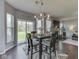 Stylish dining area with a modern chandelier opens to a living room with a fireplace and backyard access at 8926 New Heritage Ct, Indianapolis, IN 46239