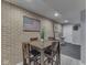 Basement dining area with brick accent wall, wood table, leather chairs, and an American flag at 8926 New Heritage Ct, Indianapolis, IN 46239
