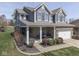 Charming exterior view showcasing a two-story home with a covered front porch and manicured lawn at 8926 New Heritage Ct, Indianapolis, IN 46239