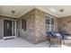 Cozy front porch with brick siding, comfortable seating, and 'Welcome' sign at 8926 New Heritage Ct, Indianapolis, IN 46239