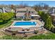 Aerial view of a backyard featuring a pool, patio, and lush landscaping at 1016 Silver Lake Ct, Greenwood, IN 46142