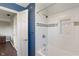 Bright bathroom features a tub and shower with white tile and a dark blue accent wall at 1016 Silver Lake Ct, Greenwood, IN 46142