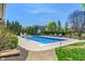 Backyard pool surrounded by lush greenery and a hardscape patio with seating at 1016 Silver Lake Ct, Greenwood, IN 46142