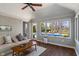 Sunroom featuring brick walls, wood flooring, and views of the backyard pool at 1016 Silver Lake Ct, Greenwood, IN 46142