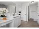 Clean and modern bathroom with white vanity, decorative mirror, and wood-look flooring at 10524 Broadford St, Indianapolis, IN 46239