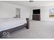 Spacious bedroom featuring carpet flooring, a dresser, and a mounted television at 10524 Broadford St, Indianapolis, IN 46239