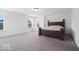 Bright bedroom featuring carpet flooring, a wood bed frame, and two windows at 10524 Broadford St, Indianapolis, IN 46239