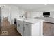 Stylish kitchen island featuring a white countertop, farmhouse sink, and modern faucet, connecting to the living area at 10524 Broadford St, Indianapolis, IN 46239
