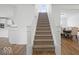 Staircase with carpeted steps and white railings leading to a dining area at 10524 Broadford St, Indianapolis, IN 46239