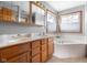 Bathroom with dual sinks, wood cabinets, and a soaking tub provides a spa-like experience at 1121 Retford Ct, Greenwood, IN 46143