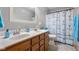 Bathroom with a double sink vanity and a blue and white shower curtain at 1121 Retford Ct, Greenwood, IN 46143