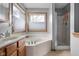 Bright bathroom features a soaking tub, glass shower, and dual windows for natural light at 1121 Retford Ct, Greenwood, IN 46143