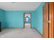 Teal bedroom featuring neutral carpet, a wood door and an open door frame leading to another room at 1121 Retford Ct, Greenwood, IN 46143