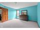 Spacious bedroom featuring teal walls, neutral carpet, and a dark wood dresser at 1121 Retford Ct, Greenwood, IN 46143