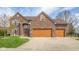 Lovely brick home featuring a three-car garage, manicured lawn, and stylish wooden window shutters at 1121 Retford Ct, Greenwood, IN 46143