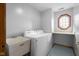 A clean laundry room featuring a washer, dryer, utility sink, and unique octagon window at 1121 Retford Ct, Greenwood, IN 46143
