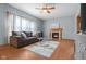 Comfortable living room with a cozy fireplace, neutral-toned sofa, and ceiling fan at 1121 Retford Ct, Greenwood, IN 46143