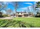 The backyard showcases a partially renovated home with ample green space at 11625 Rolling Springs Dr, Carmel, IN 46033
