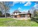 The backyard features a partially renovated home and lush green grass at 11625 Rolling Springs Dr, Carmel, IN 46033