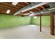 A large basement with concrete floors, green painted walls, and exposed ceiling ducts ready for customization at 11625 Rolling Springs Dr, Carmel, IN 46033