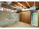 View of basement with concrete walls, exposed ceiling, and wooden panels, offering an unfinished space to customize at 11625 Rolling Springs Dr, Carmel, IN 46033