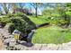 Scenic creek flowing through the lush backyard, with a charming stone bridge at 11625 Rolling Springs Dr, Carmel, IN 46033