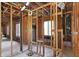 Unfinished interior showing exposed wood framework, plumbing, and large windows for a modern renovation project at 11625 Rolling Springs Dr, Carmel, IN 46033